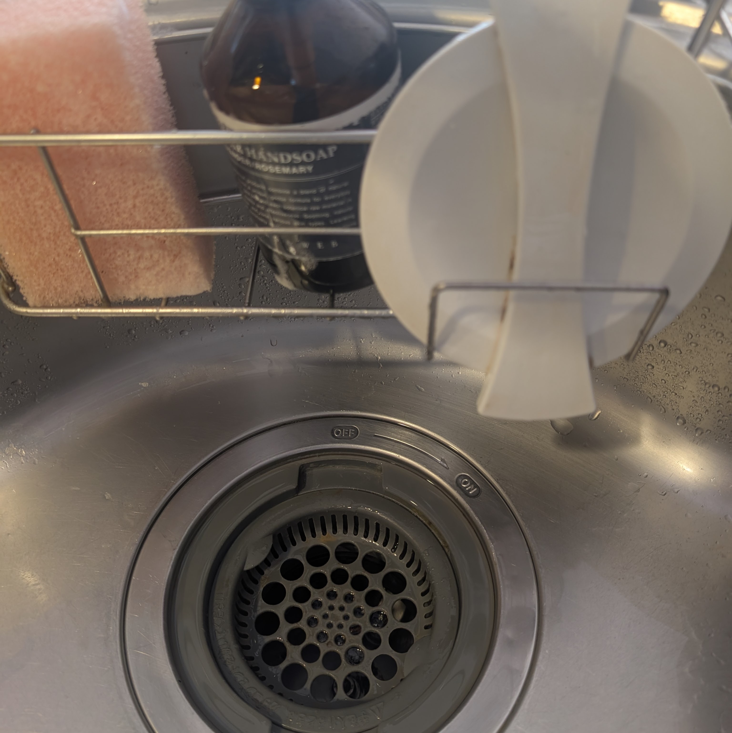 ディスポーザーの蓋がシンク直置きの状態と、セリアのホルダーに収まってスッキリした状態のビフォーアフター写真